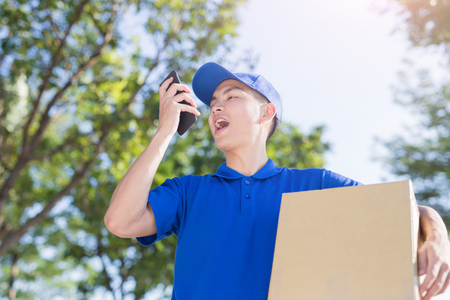deliveryman hold box and talk on phone, asianの写真素材
