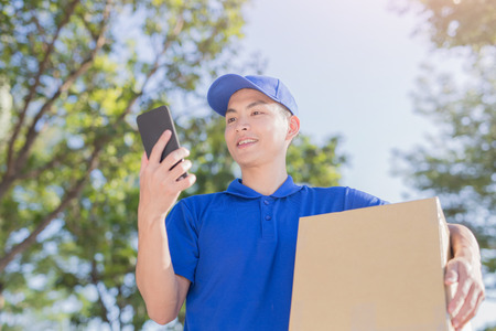 deliveryman hold box and talk on phone, asianの写真素材