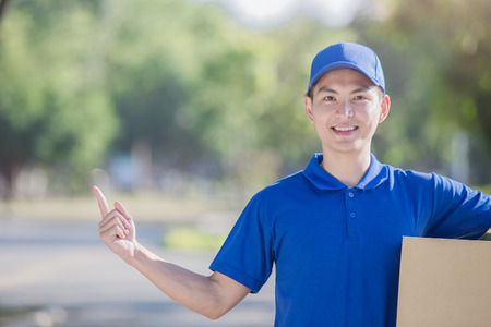 deliveryman hold  box and show something, asianの写真素材