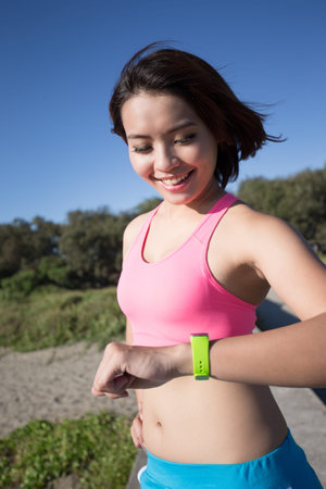 Health sport woman wearing smart watch device with touchscreen doing exercisesの写真素材