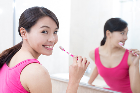 beauty woman brush tooth and smile happily in the bathroomの写真素材