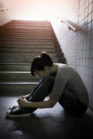 depressed woman feel upset and sit in undergroundの写真素材