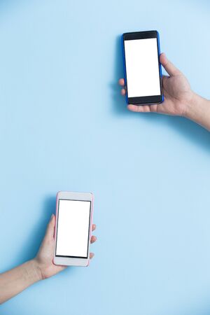 hand take smart phone on blue backgroundの写真素材