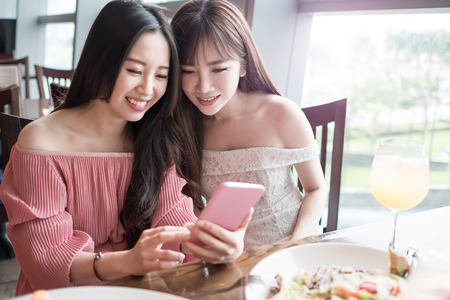 beauty women use phone and dine in restaurantの写真素材