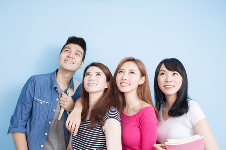 happy group student look somewhere on the blue backgroundの写真素材