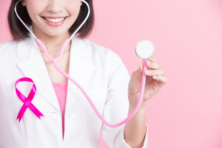 woman doctor take stethoscope with breast cancer prevent concept on pink bakcgroundの写真素材