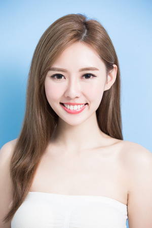 beauty woman smile happily with health teeth on the blue backgroundの写真素材