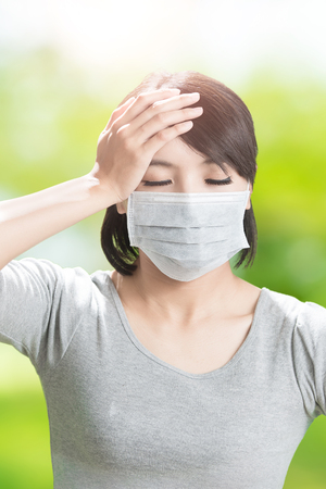 woman feel headache on the green backgroundの写真素材