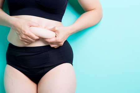 Fat overweight woman body with blue backgroundの写真素材