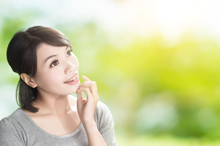 woman look somewhere on the green backgroundの写真素材