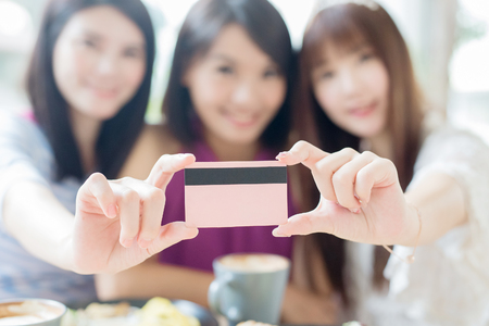 close up of woman friends smile and take credit card in restaurantの写真素材