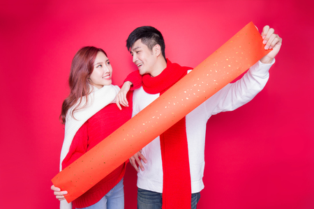 couple show couplets with chinese new year on red backgroundの写真素材