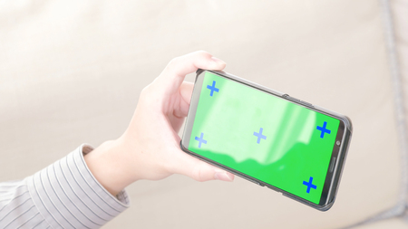 man take cell phone with green screen in the homeの写真素材