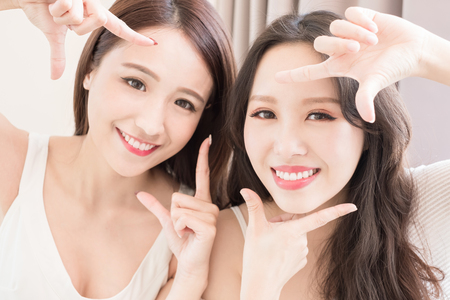 two beauty woman making frame gesture in the homeの写真素材