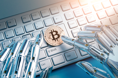 Robot hand with bitcoin on the tableの写真素材