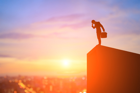 silhouette of businessman feel upset on the mountainの写真素材