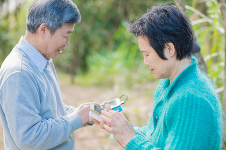old couple use phone in the parkの写真素材