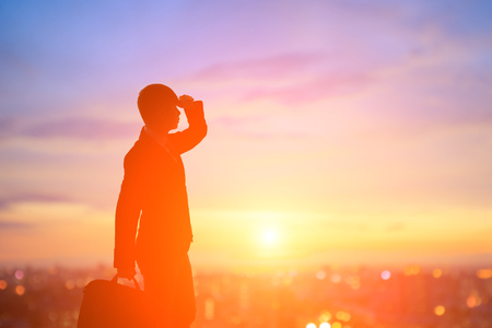 silhouette of business man look somewhere with sunsetの写真素材
