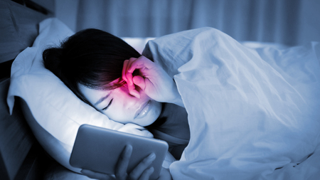 woman use phone and feel unhappy on the bedの写真素材