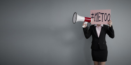 business woman take me too billboard and microphone on the gray backgroundの写真素材