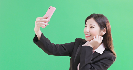 businesswoman selfie happily on the green backgroundの写真素材