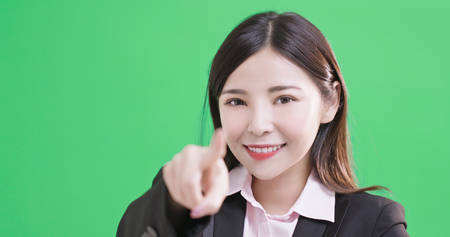 businesswoman pointing you on the green backgroundの写真素材