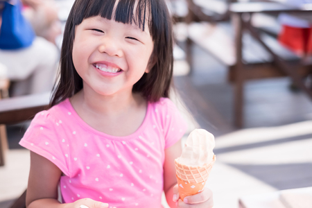 cute girl eat ice cream and smile happilyの写真素材