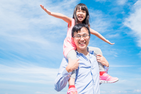 father and daughter smile happily with blue skyの写真素材