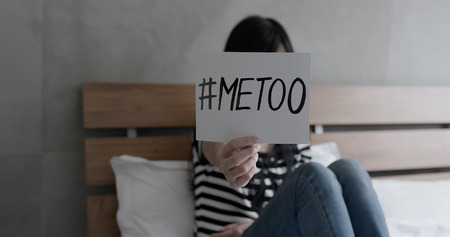 woman sit on the bed and take metoo billboard with against sexual harassmentの写真素材