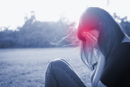 woman sit on the grass and feel headacheの写真素材