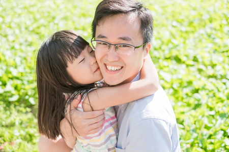 father and daughter smile happily in the parkの写真素材