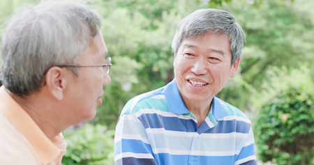 old man chatting happily in the parkの写真素材