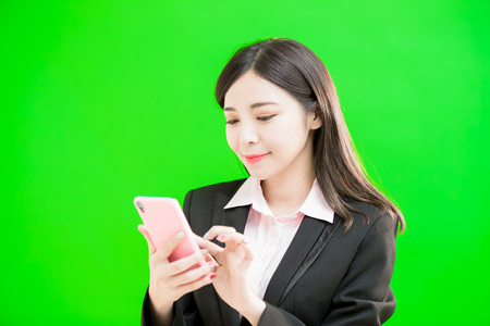 businesswoman use phone on the green backgroundの写真素材