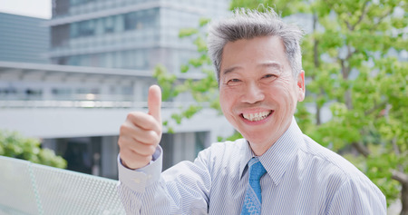 old businessman smile happily and show thumb upの写真素材