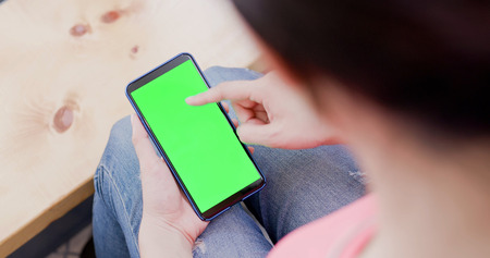 woman take cell phone with green screenの写真素材