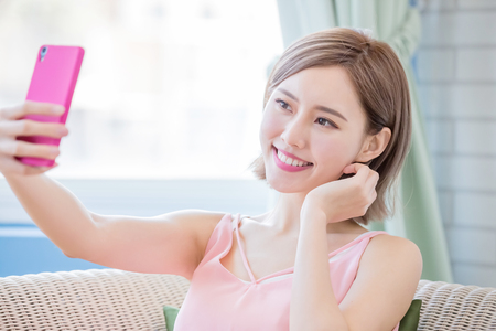 woman use phone selfie happily at homeの写真素材