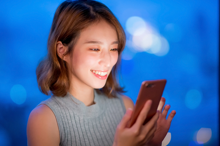 woman use phone happily at home in the eveningの写真素材