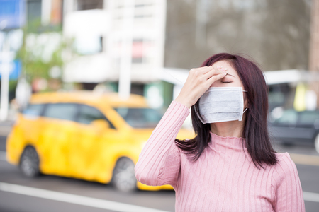 woman feel headache and wear mask in the cityの写真素材