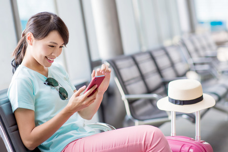 woman sit and use phone happily in the stationの写真素材