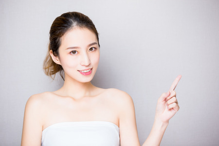 beauty skin care woman show something on the gray backgroundの写真素材