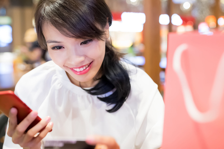 woman use phone and credit card in the restaurantの写真素材
