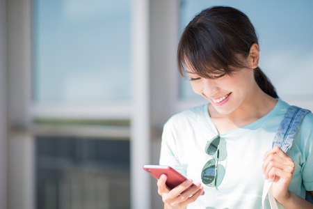 woman stand and use phone happily in the Stationの写真素材