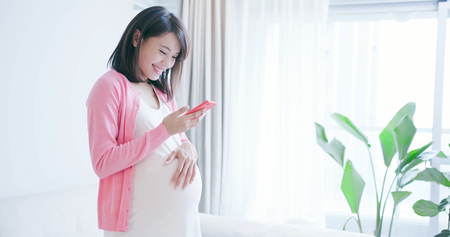 pregnant woman use smart phone at home