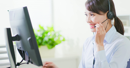 Young friendly operator woman agent with headsets working in call centerの写真素材