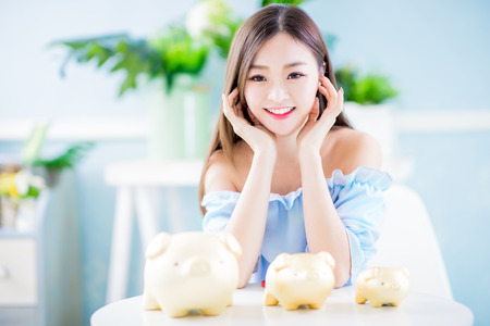 Happy woman with her golden piggy bank and feel happy at homeの写真素材