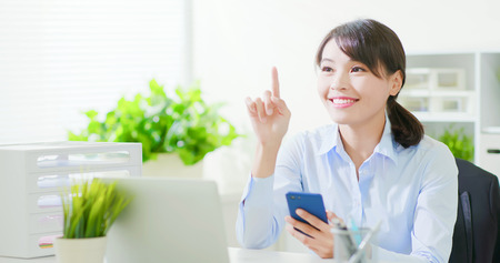 business woman use a smart phone and operate virtual screen interface in the officeの写真素材