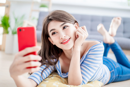 Young beautiful woman taking selfie from hand with phoneの写真素材