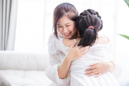 Daughter give mom a hug and mom smile happilyの写真素材