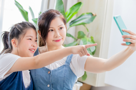 Mom and daughter take selfie together happilyの写真素材