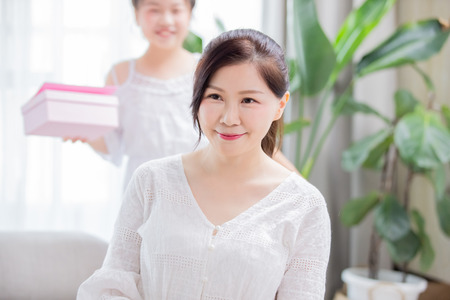 Daughter give mom a surprise to celebrate mother day at homeの写真素材